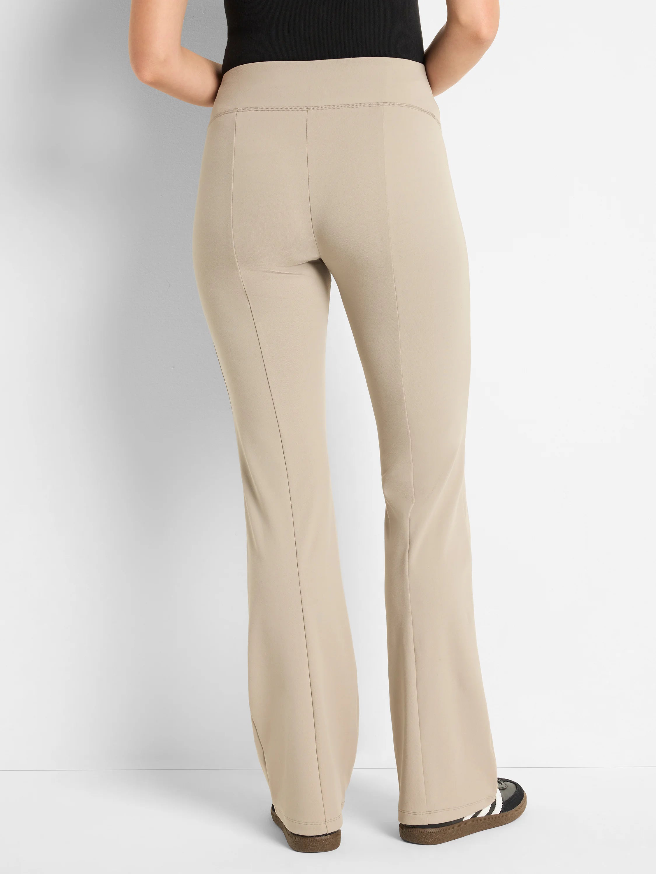 Beige bootcut pants; high-waisted, with center seams.