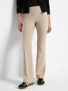 Beige bootcut pants; high waist, slight flare.  Model wears black shoes.