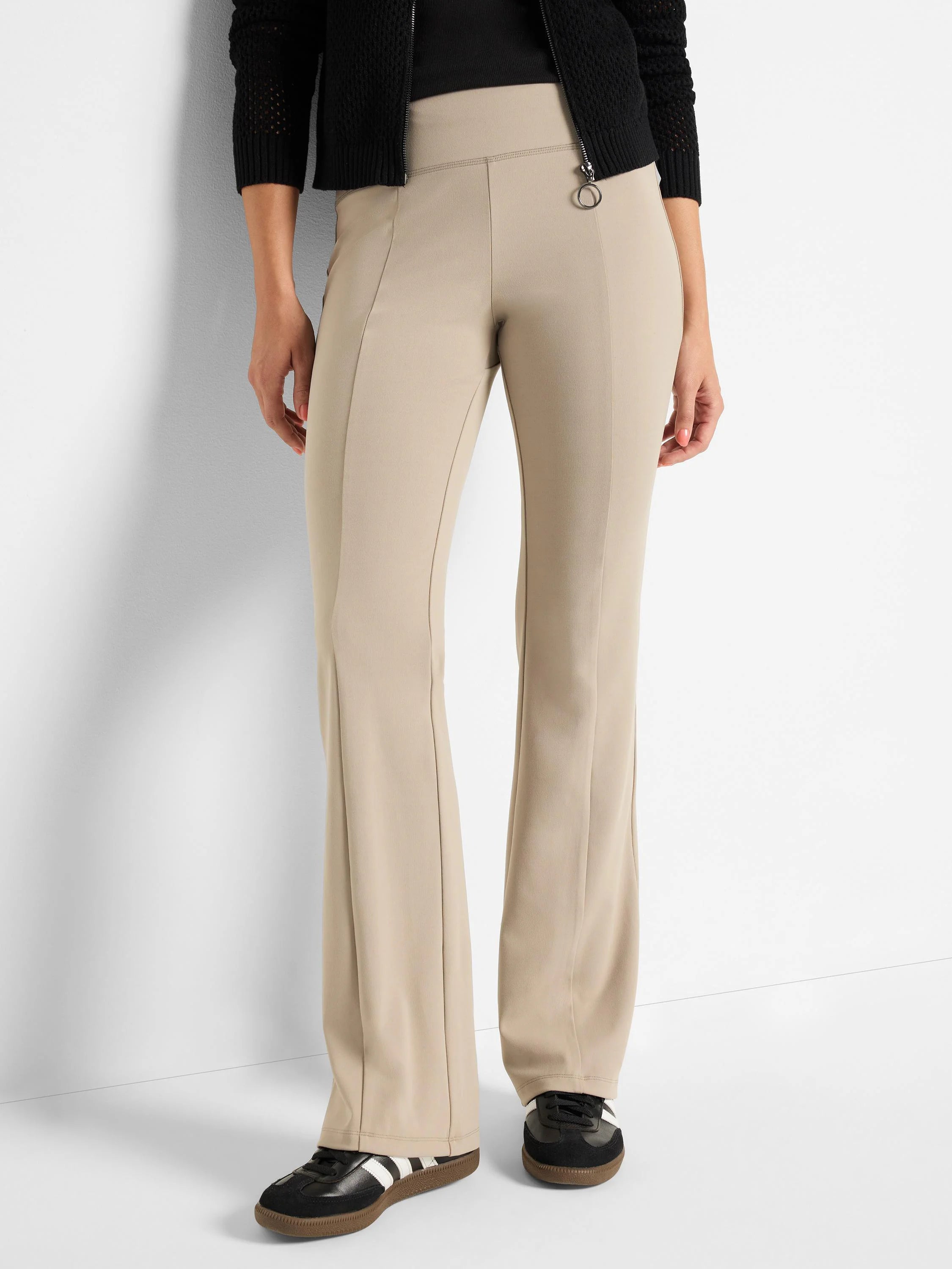 Beige bootcut pants; high waist, slight flare.  Model wears black shoes.