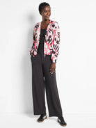 Black wide-leg pants; model wears a pink, black, and gray patterned jacket.