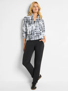 Black and white abstract print popover, half-zip.  Paired with black straight-leg pants.