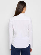 White long-sleeve collared shirt, viewed from the back.  The shirt is fitted and has a curved hem.