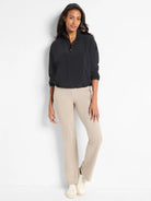 Black half-zip pullover with drawstring hem, shown with light beige pants.