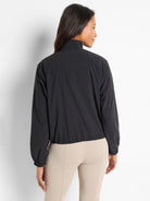 Black popover with a mock neck, long sleeves, and elasticized hem.  Shown from the back.
