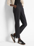 Black ankle-length pants with side slits, shown on a model.