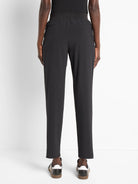 Black ankle-length pants with elastic waistband and back pockets.  Model is wearing black shoes.