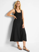 Black midi dress; fitted bodice, flared skirt. Square neckline, sleeveless.