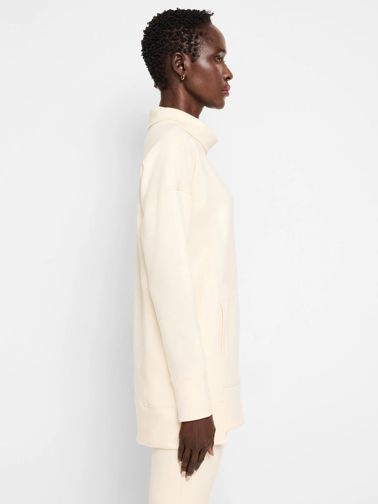Off-white tunic with funnel neck, long sleeves, and a side pocket.