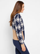 Navy blue and beige sweater. Geometric diamond pattern on upper half, solid beige on lower half. Half-zip neckline.