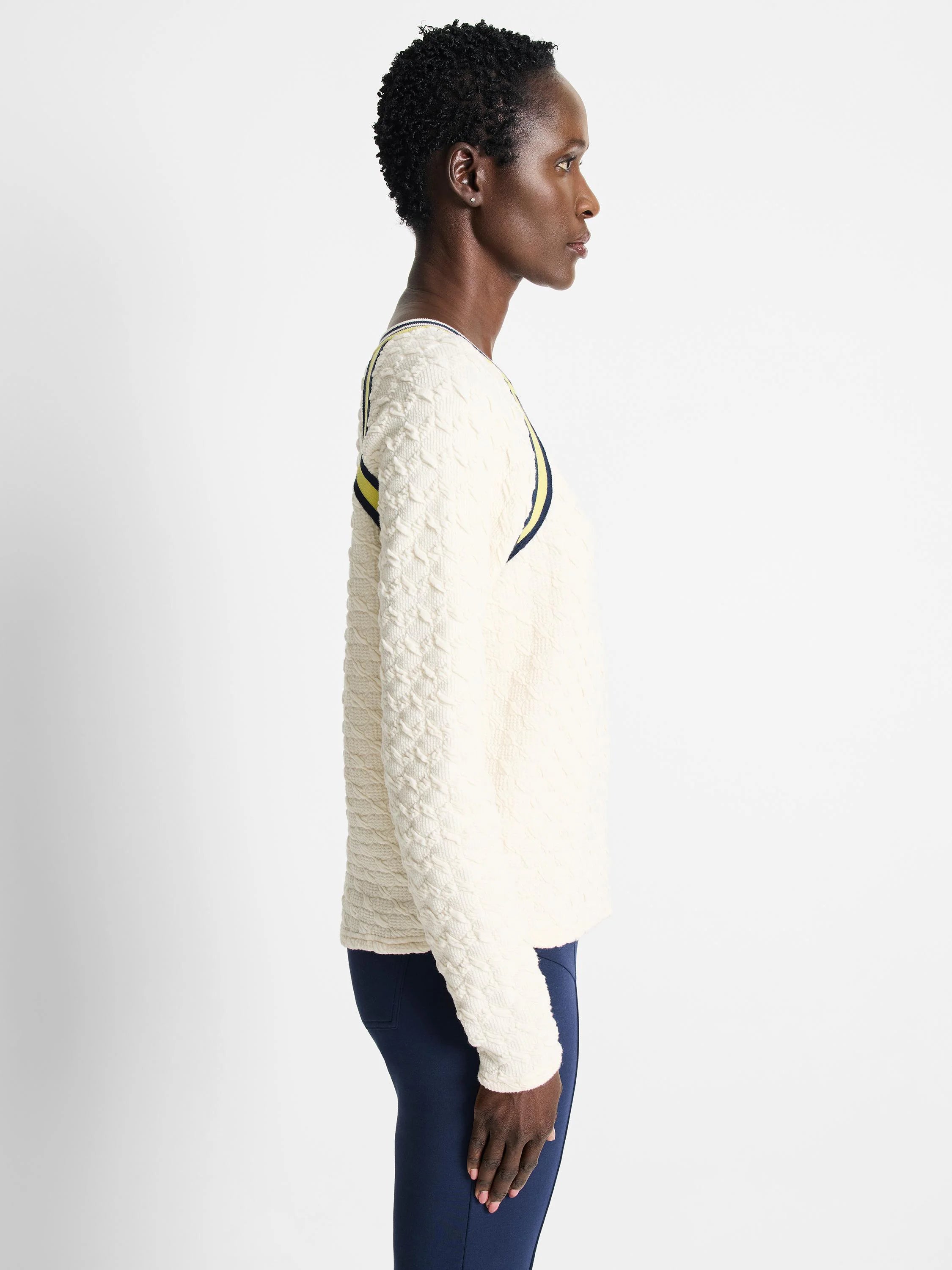 Off-white textured pullover sweater with yellow and navy blue stripes across the shoulders.