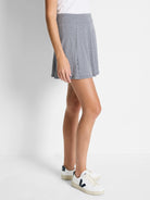 A-line skort in navy and white gingham.  Shows a side view on a model.