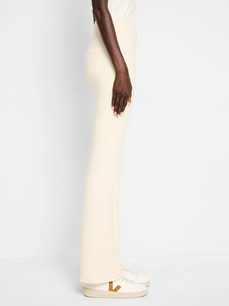 Off-white bootcut pants, seamed detailing.  Side view.