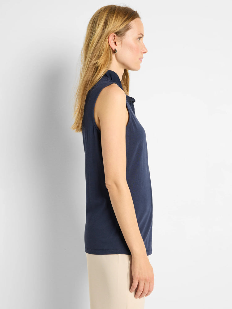 Navy blue sleeveless tank with a high, ruffled neckline.