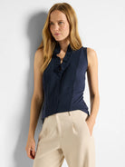 Navy blue sleeveless tank with a ruffled V-neckline.