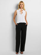 White sleeveless tank with a ruffled V-neckline.