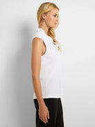 White sleeveless tank with a ruffled mock neck.