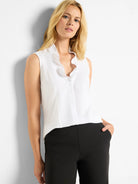 White sleeveless tank with a ruffled V-neckline.
