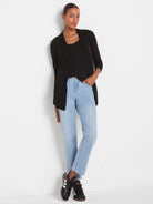 Black scoop neck tank top with a shirt tail hem, worn under a black cardigan.