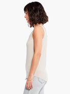 Beige sleeveless tank top with a curved hem, modeled in profile.