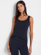 Navy blue tank top with a scoop neck, sleeveless design, and relaxed fit. Shown partially tucked in.
