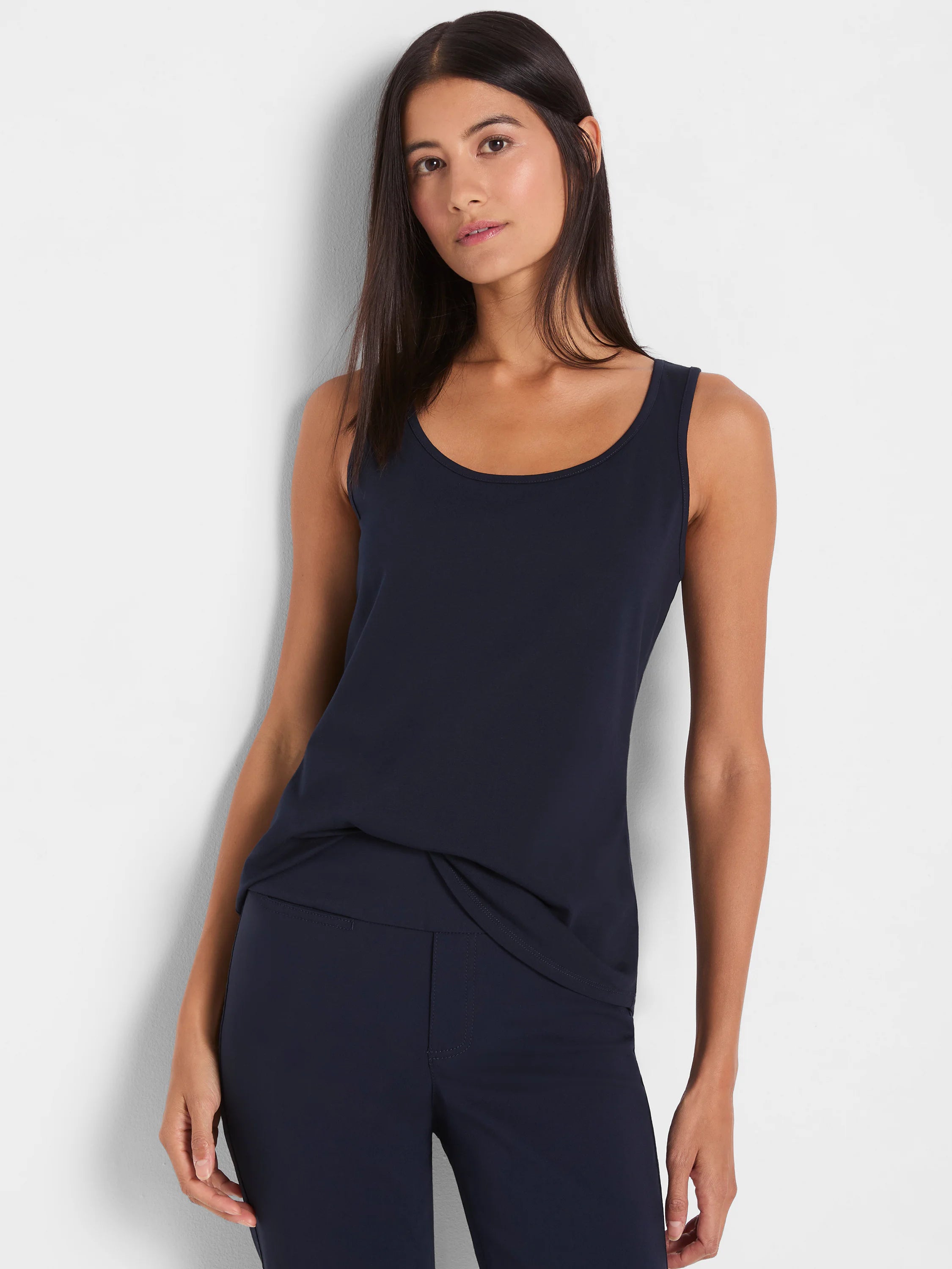 Navy blue tank top with a scoop neck, sleeveless design, and relaxed fit. Shown partially tucked in.