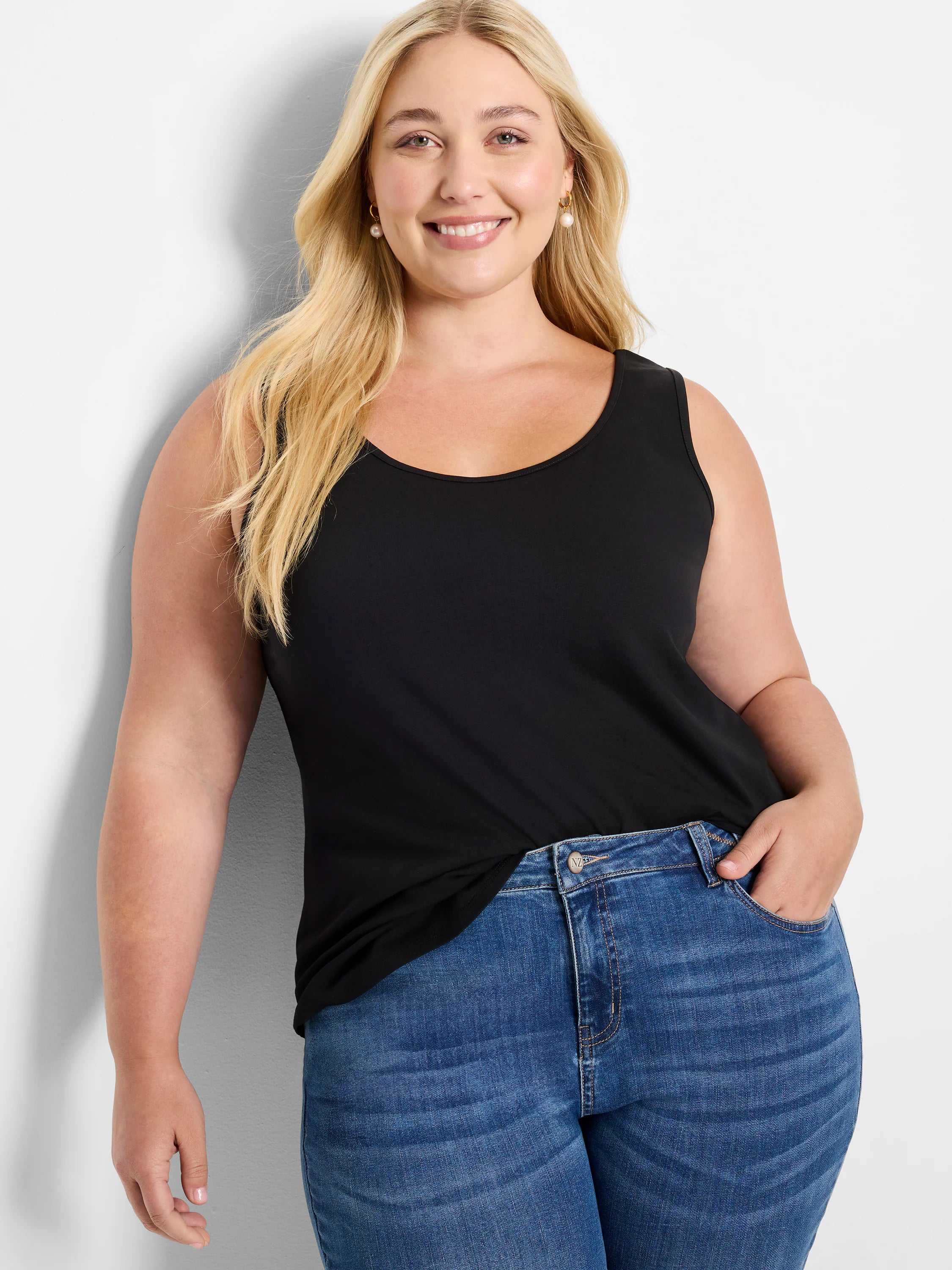 Black sleeveless scoop neck tank top with a shirt tail hem, worn by a woman.