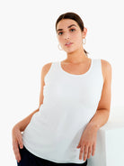 White tank top with a scoop neck and a curved shirttail hem.