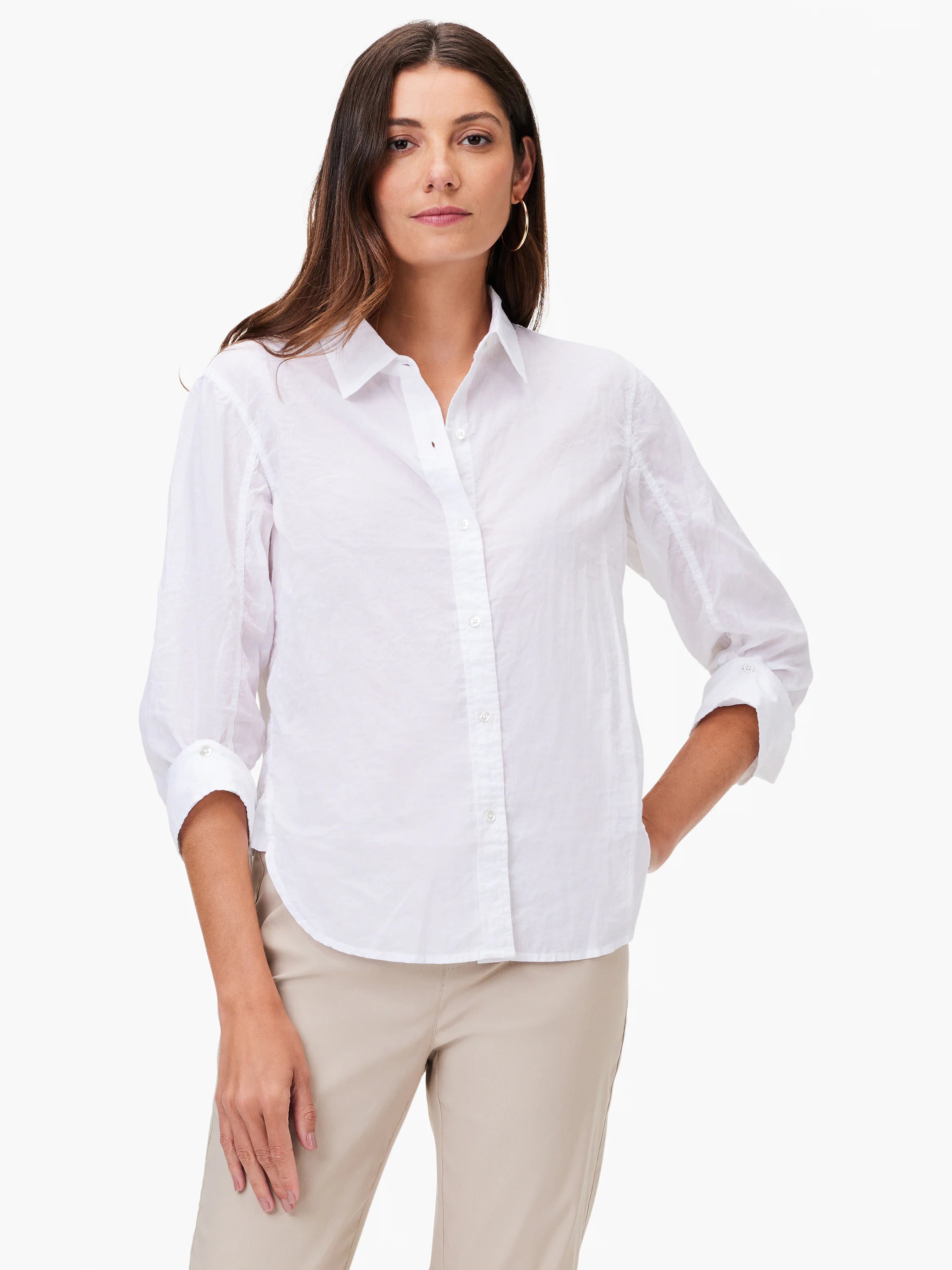 White collared button-up shirt with sleeves rolled up, crinkled texture. Worn by a woman with light beige pants.