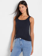 Dark navy sleeveless scoop neck tank top, smooth fit on model.