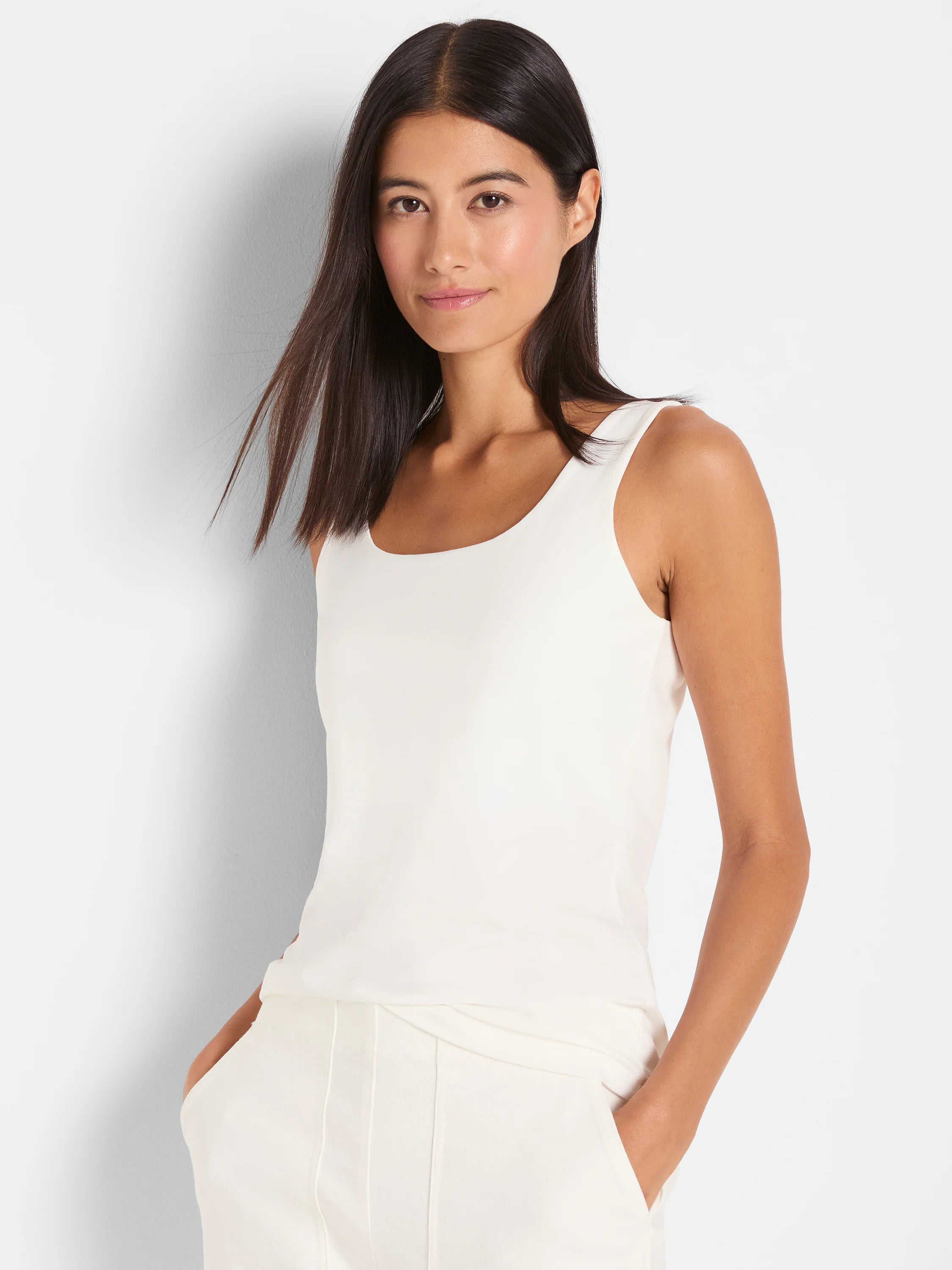 Off-white sleeveless tank top with a scoop neck. Shown on a model.