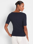 Navy ribbed elbow-sleeve boatneck tee, fitted, worn by model from behind.