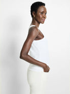 White high-neck tank top, smooth fabric, modeled from the side.