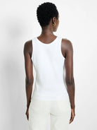 White High Neck Tank Top with a scoop back. Fitted, shown from behind on a model wearing light pants.