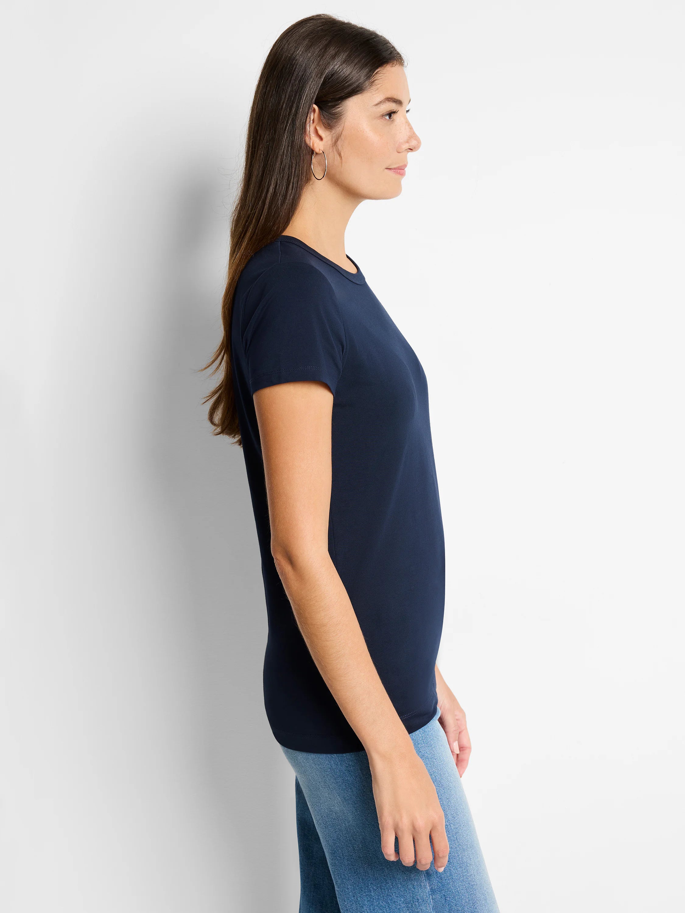 A navy knit crew neck t-shirt with short sleeves, worn by a woman in profile.