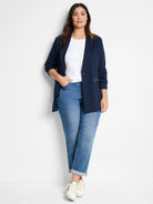 White crew neck knit t-shirt on a model, partially covered by a navy blazer.