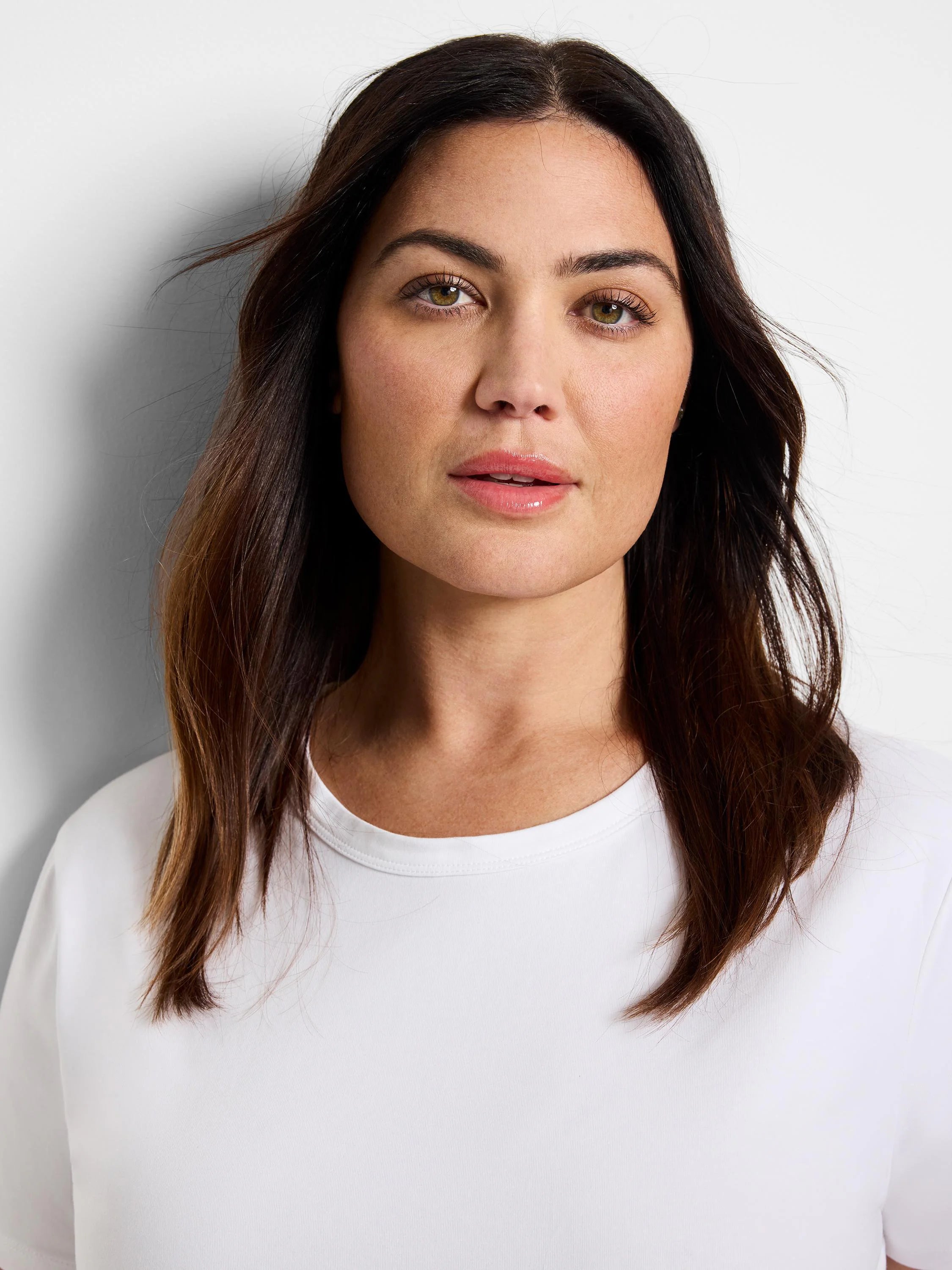 White crew neck t-shirt with smooth knit fabric and a banded collar.