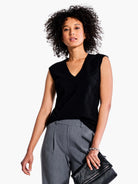 Black v-neck sleeveless top.  Model is wearing gray pants.
