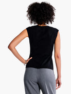 Black v-neck sleeveless top, shown from the back.  Model also wears gray pants.