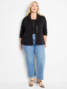 Black knit blazer with lapel collar, three decorative gold-tone buttons down front, and four flap pockets with gold buttons.