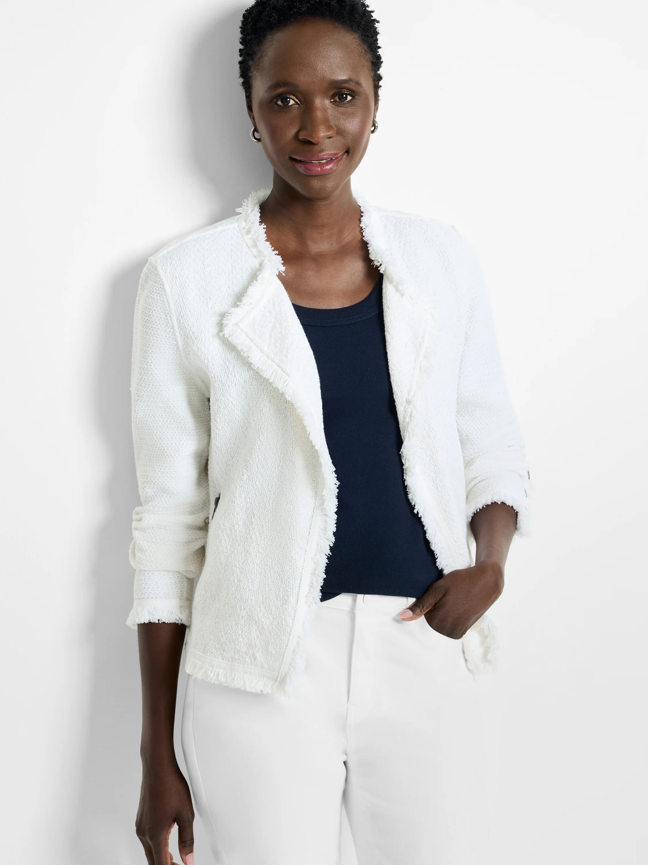 White knit jacket with fringe along the collar, front opening, and cuffs.