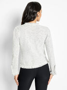 Speckled light gray mix knit jacket with fringe at collar, hem, and cuffs. Model seen from back.