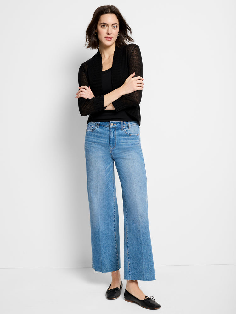 Lightweight, sheer black knit shrug with long sleeves and an open front, worn over a cami and cropped wide-leg jeans.