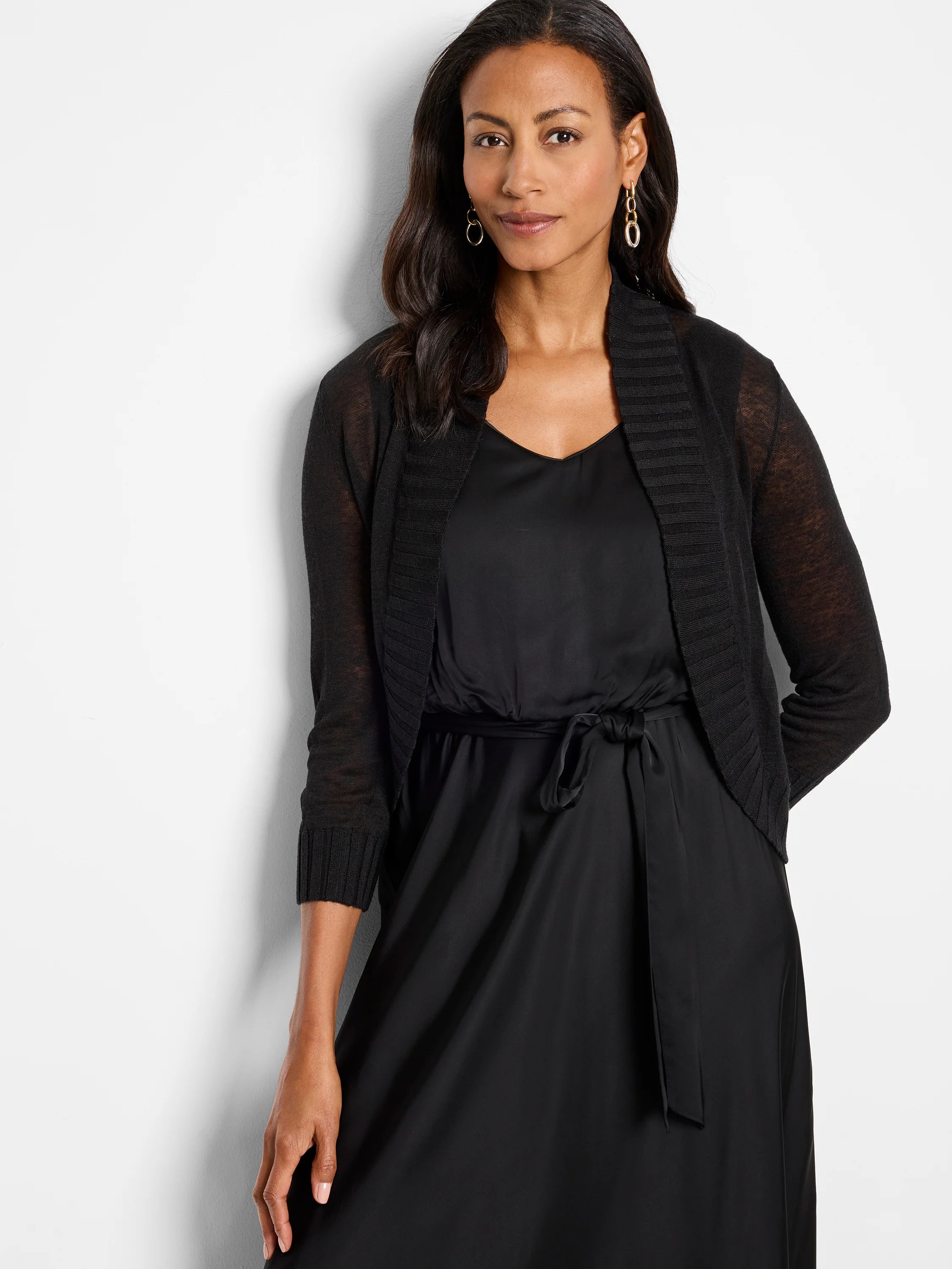 Black cropped bolero cardigan with 3/4 sheer knit sleeves and ribbed open front.
