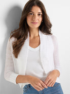 Sheer white knit bolero cardigan with a cropped length, open front, shawl collar, and ribbed trim on the sleeves.