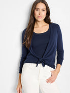 Navy blue fine knit cardigan, tied at front creating a V-neck, with long sleeves and ribbed cuffs.