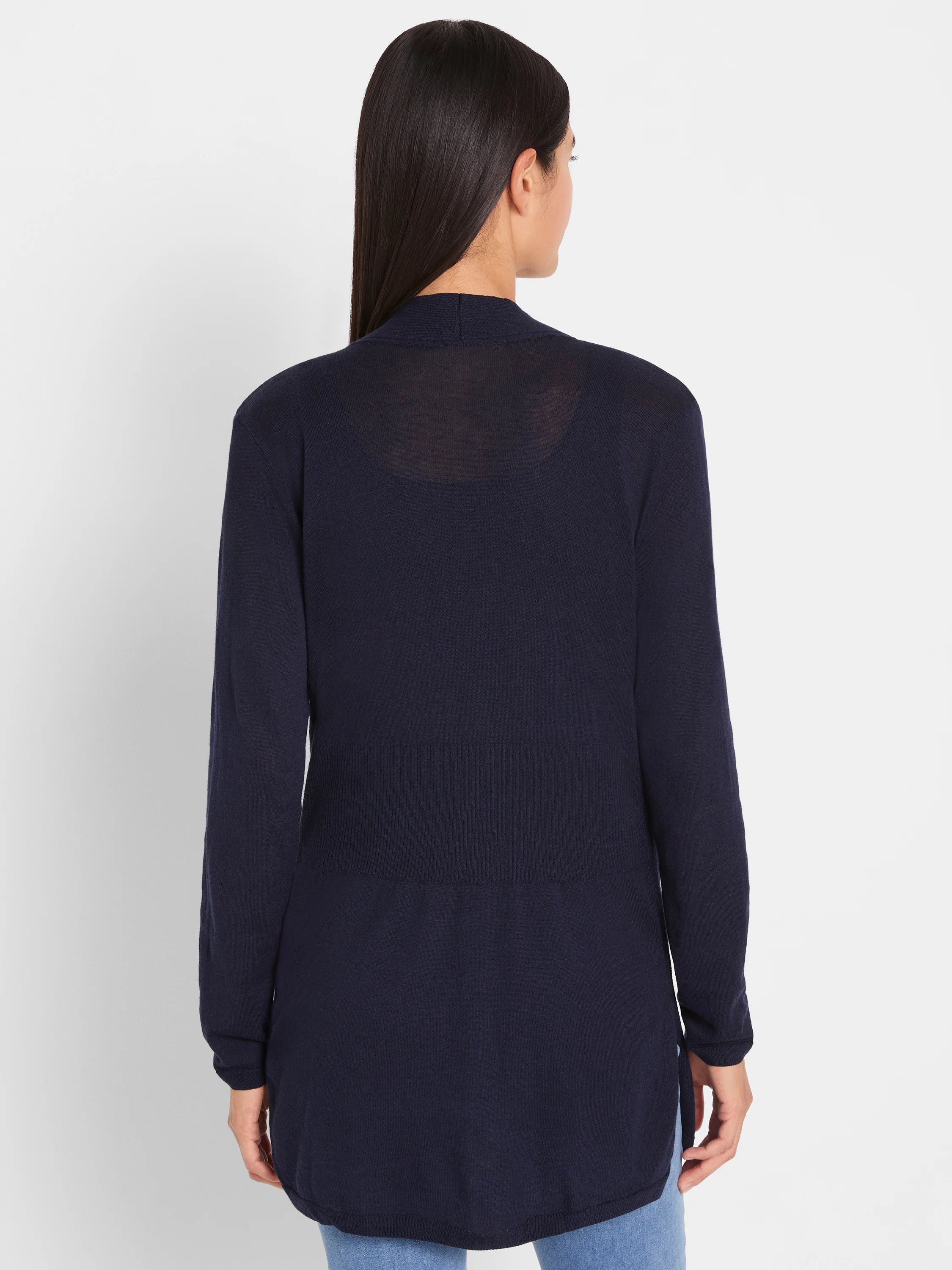 Dark blue knit cardigan, back view. Features long sleeves, a ribbed waist, curved tunic hem, and subtle sheer upper back.