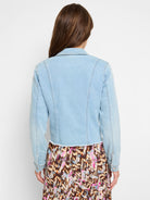 Cropped light wash jean jacket with fitted back panels and a distressed bottom edge.