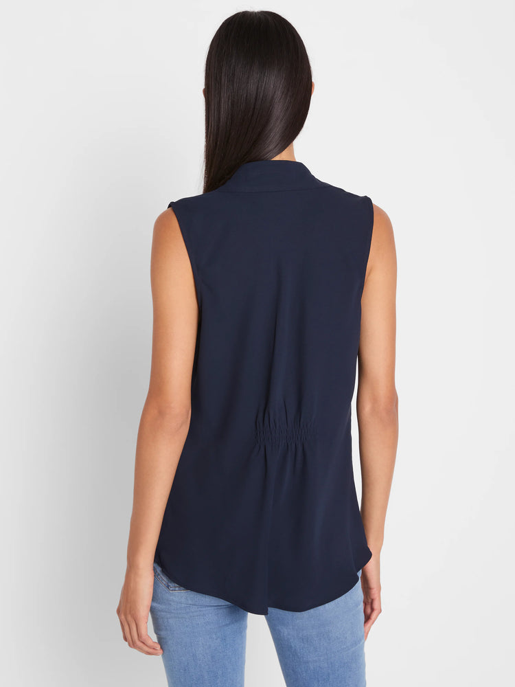 Navy blue sleeveless top with a banded collar and gathering detail on the lower back, shown from behind.
