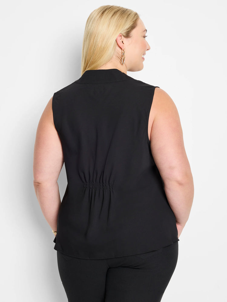 Black sleeveless top with a stand collar and gathered detail at the lower back, worn by a woman facing away.