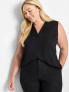 Black sleeveless V-neck top with a hidden front placket and a relaxed drape, worn by a woman.